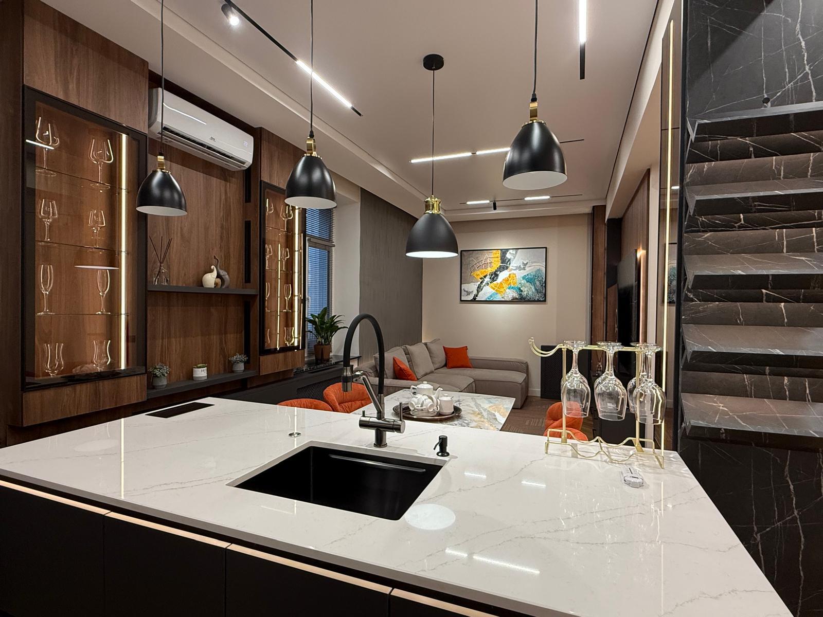 Bucătărie cu insulă quartz alb și living integrat